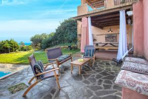 a patio with chairs and a couch and a fireplace at Villa Sa Pintadera private pool in Stintino