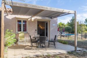 a patio with a table and chairs on it at Gîte Chêne ou Murier in Les Vans