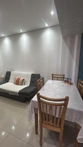 a living room with a table and a couch at Biquinha - Praça 22 de Janeiro in São Vicente +10 photos