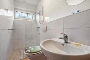 a white bathroom with a sink and a toilet at Ferienwohnung Heidi in Bielatal +21 photos