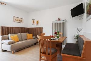a living room with a couch and a table at Auelehof Laives in Laives
