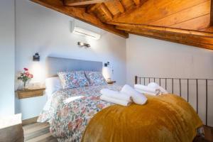 a bedroom with a bed with towels on it at Cueva Secreta Güejar in Güéjar-Sierra