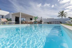 a swimming pool in front of a villa at The Suite Villa in Playa Blanca