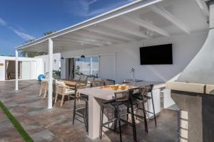 a patio with a table and chairs and a television at The Suite Villa in Playa Blanca