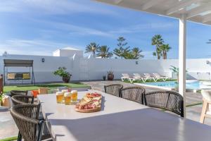 a table with pizza and drinks on a patio at The Suite Villa in Playa Blanca