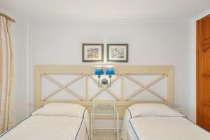a bedroom with two beds and a stool in it at Playa Delphin 304 in Puerto Naos