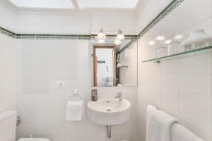 a white bathroom with a sink and a mirror at Playa Delphin 304 in Puerto Naos +19 photos