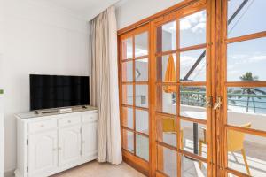 a room with a sliding glass door and a television at Playa Delphin 304 in Puerto Naos