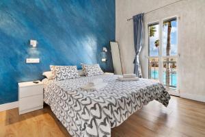 a bedroom with a bed and a blue wall at Bungalow Green Oasis in San Bartolomé