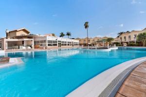a large swimming pool with blue water in a resort at Bungalow Green Oasis in San Bartolomé