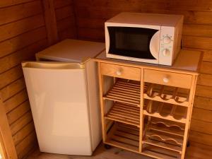 a microwave sitting on top of a refrigerator next to a refrigerator freezer at Barrel Orange in Saint-André