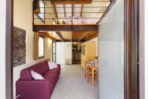 a living room with a purple couch and a table at Melograno Agriturismo La Ferla in Toirano