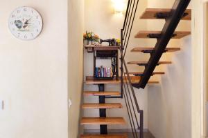 a staircase with wooden treads and a clock on the wall at Melograno Agriturismo La Ferla in Toirano