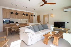 a living room with a white couch and a kitchen at Villa Alexandra in Lefkada
