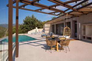 a patio with a table and chairs next to a pool at Villa Alexandra in Lefkada