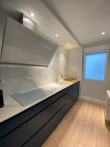 a large kitchen with a sink and a window at 'Socaire' Ribadesella in Ribadesella