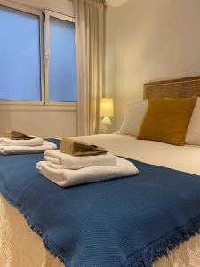 a bedroom with two towels on a bed with a window at 'Socaire' Ribadesella in Ribadesella