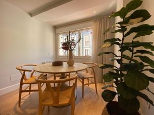 a dining room with a table and chairs and a plant at 'Socaire' Ribadesella in Ribadesella