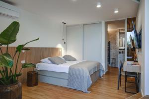 a bedroom with a bed and a table and a plant at Maravida Vacation Rooms in Dobrovo