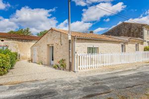 a stone house with a white fence at Gite Barrail du Moulin in Bégadan