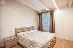 a small bedroom with a bed and a window at Casa Penasa Appartamento 1 in Commezzadura