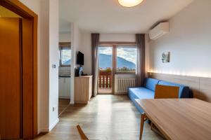 a living room with a blue couch and a table at Gartenheim App Maria in Schenna
