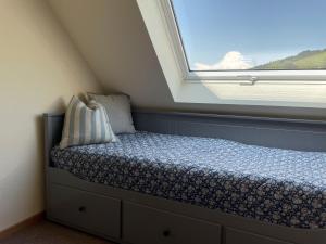 a small bed in a room with a window at Gullerhof Ferienwohnung - Köpfle in Glottertal +16 photos