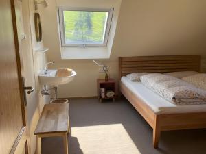 a bedroom with a bed and a sink and a window at Gullerhof Ferienwohnung - Köpfle in Glottertal