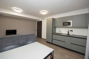 a kitchen with white and gray cabinets and a table at Appartamenti Suly 4 - Cir0085 in Saint Vincent
