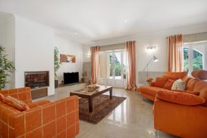 a living room with orange furniture and a fireplace at Foz Fancy Fun in Foz do Arelho