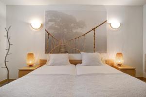 a bedroom with a large bed with two lamps at Foz Fancy Fun in Foz do Arelho +32 photos