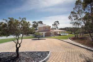 a house with a tree in front of a brick driveway at Foz Fancy Fun in Foz do Arelho