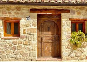 a stone building with a wooden door and two windows at El Kubo in Olba