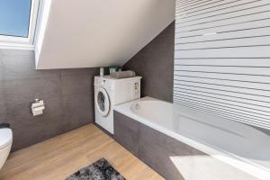 a bathroom with a tub and a washing machine at Zeichner in Geisingen +16 photos