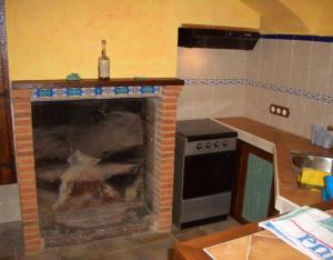 a kitchen with a brick fireplace with a stove at Casa Gimeno in Bocairent +12 photos