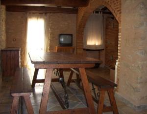 a wooden table in a room with a television at Casa Gimeno in Bocairent