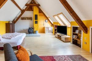 a living room with yellow walls and a flat screen tv at La Rose in Tengen
