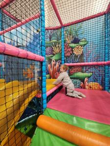 a baby playing on a slide in a play structure at Spacious accomodation 188 Unity Beach sleeps 6 Centrally located Pet friendly Pets Stay Free in Brean