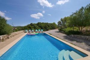a swimming pool with chairs and a swimming pool at Sa Corbaia Nova in Artá