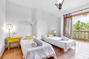two beds in a white room with a window at Sa Corbaia Nova in Artá +17 photos