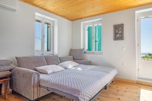 a living room with a couch and two windows at Milia's House Ithaca in Vathi +20 photos