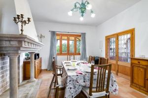 a dining room with a table and a fireplace at Sa Corbaia Nova in Artá
