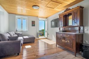 a living room with a couch and a wooden ceiling at Milia's House Ithaca in Vathi