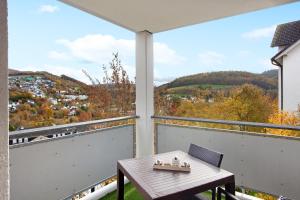 a balcony with a table and a view of a city at Fewo am Hennesee in Meschede