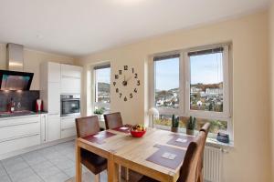 a kitchen and dining room with a table and a clock at Fewo am Hennesee in Meschede