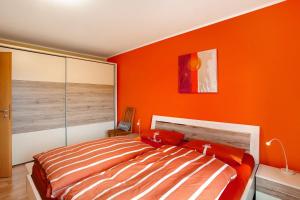 a bedroom with orange walls and a bed at Fewo am Hennesee in Meschede