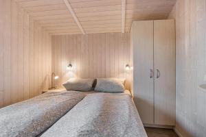 a bedroom with a large bed and a cabinet at Skipper-Lodge Nord in Kosel
