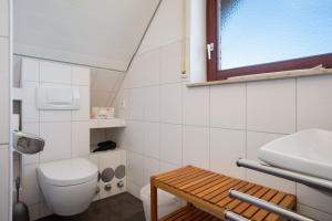 a bathroom with a toilet and a sink and a window at Gästehaus Heinemann - Dg4 in Langenargen +37 photos