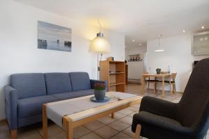 a living room with a couch and two chairs and a table at Gästehaus Heinemann - Dg4 in Langenargen