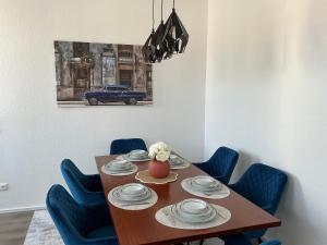 a dining room table with blue chairs and a blue car at Harzträume Thale in Thale